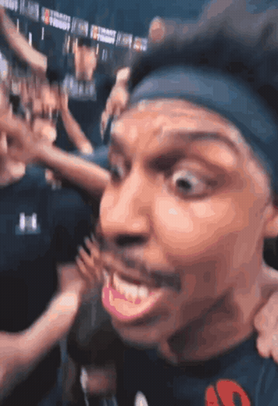 A Man Wearing A Headband With The Letter S On It Is Smiling GIF