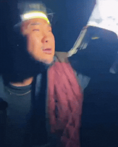 A Man Wearing A Headlamp And A Scarf Looks At Something GIF