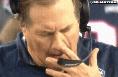A Man Wearing A Headset Is Holding His Nose While Talking On A Phone . GIF