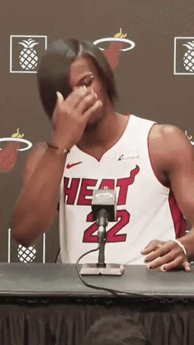 A Man Wearing A Heat 22 Jersey Is Sitting At A Table GIF
