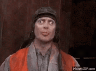 A Man Wearing A Helmet And An Orange Vest Is Making A Face . GIF