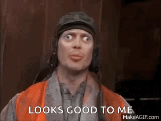A Man Wearing A Helmet And An Orange Vest Is Making A Funny Face . GIF