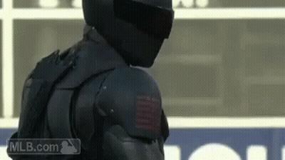 A Man Wearing A Helmet And Armor Is Standing On A Field . GIF