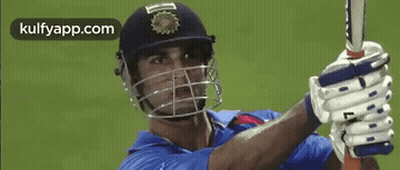 A Man Wearing A Helmet And Gloves Is Holding A Bat . GIF