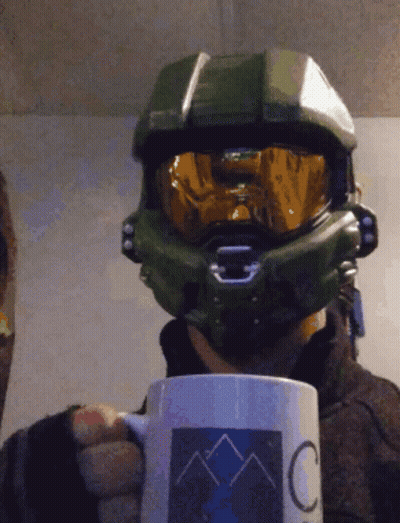 A Man Wearing A Helmet And Goggles Is Holding A Mug That Says C On It GIF