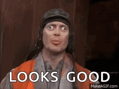 A Man Wearing A Helmet And Goggles Is Making A Funny Face And Says `` Looks Good '' . GIF