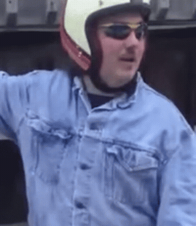 A Man Wearing A Helmet And Sunglasses Is Wearing A Denim Jacket GIF