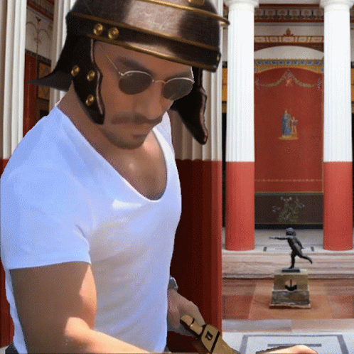 A Man Wearing A Helmet And Sunglasses Stands In Front Of A Building With Columns GIF