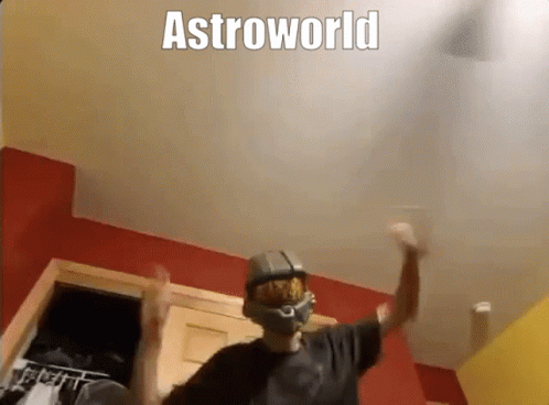 A Man Wearing A Helmet Is Dancing In A Room With The Words Astroworld Above Him . GIF