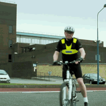 A Man Wearing A Helmet Is Riding A Bike GIF
