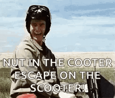 A Man Wearing A Helmet Is Sitting On A Scooter In A Field And Smiling . GIF