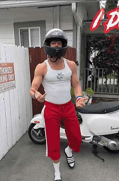 A Man Wearing A Helmet Is Standing In Front Of A Sign That Reads Authorized Parking Only GIF