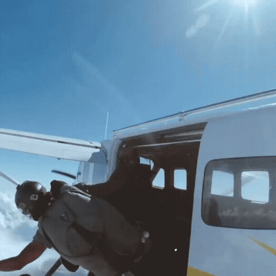 A Man Wearing A Helmet With The Letter B On It Is Getting Out Of A Plane GIF