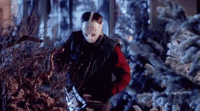 A Man Wearing A Hockey Mask And Gloves Is Cutting A Tree GIF