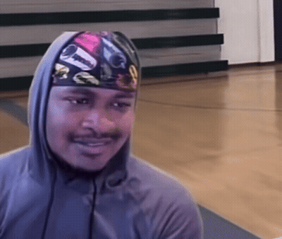 A Man Wearing A Hooded Sweatshirt And A Headband With A Picture Of A Car On It Is Smiling GIF
