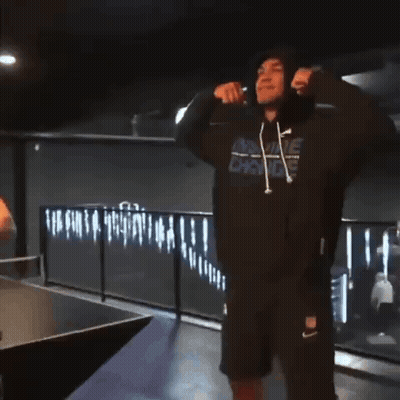 A Man Wearing A Hooded Sweatshirt With A Nike Logo On It GIF