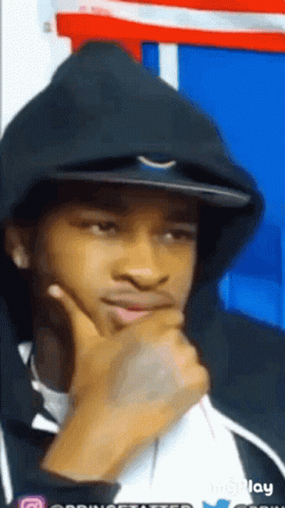 A Man Wearing A Hoodie And A Hat Is Thinking With His Hand On His Chin GIF