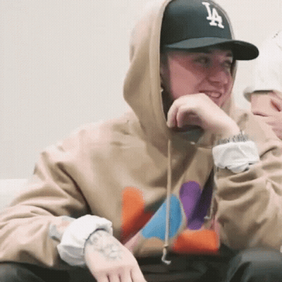 A Man Wearing A Hoodie And A La Hat GIF