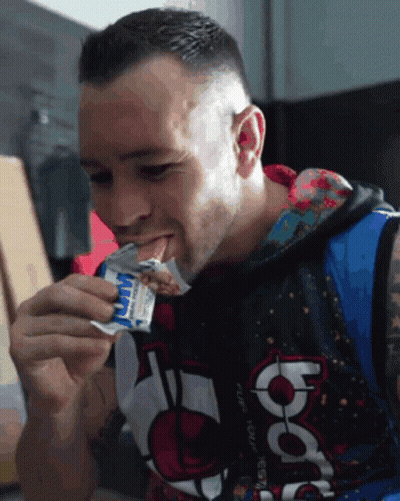 A Man Wearing A Hoodie That Says Nba Is Eating A Snack GIF
