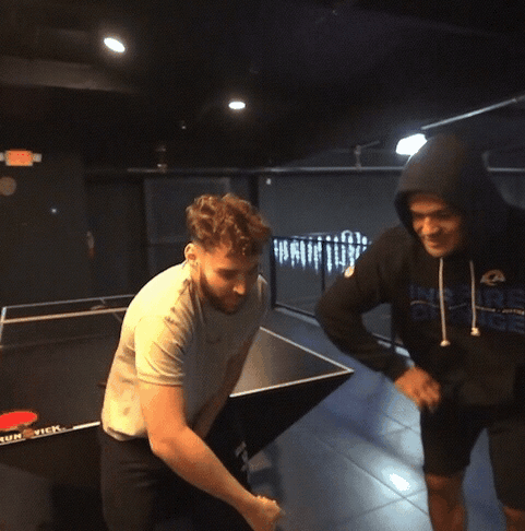 A Man Wearing A Hoodie That Says Rams Is Standing Next To Another Man GIF