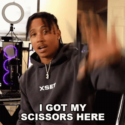 A Man Wearing A Hoodie That Says Xset On It Says I Got My Scissors Here GIF