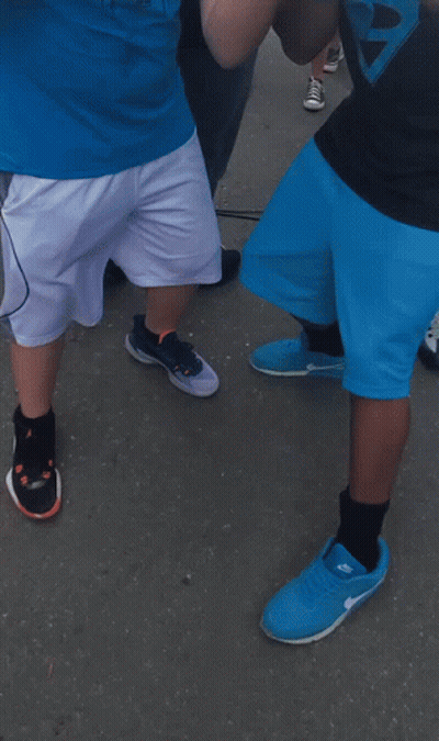 A Man Wearing A Horn Jersey Stands Next To Another Man GIF
