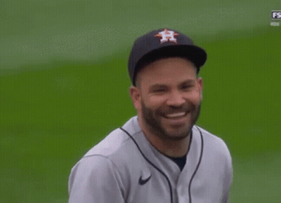 A Man Wearing A Houston Astros Baseball Jersey And Hat Is Smiling On A Baseball Field . GIF
