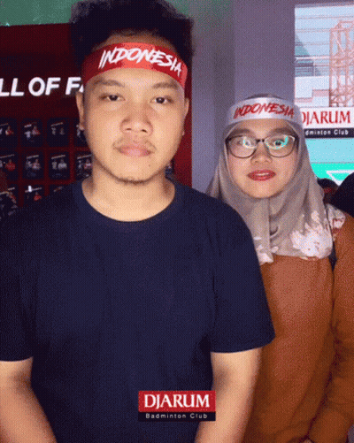 A Man Wearing A Indonesia Headband Is Standing Next To A Woman Wearing Glasses GIF