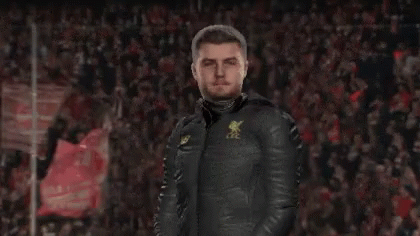 A Man Wearing A Jacket That Says Lfc Is Standing In Front Of A Crowd GIF