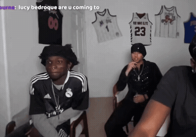 A Man Wearing A Jersey That Says 23 Sits In A Room With Other People GIF