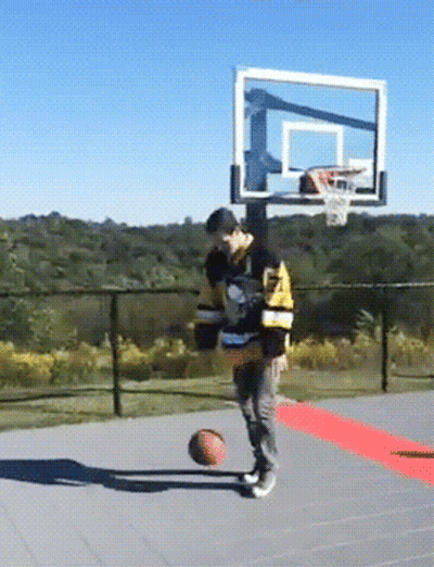A Man Wearing A Jersey That Says ' Boston Bruins ' On It Is Playing Basketball GIF
