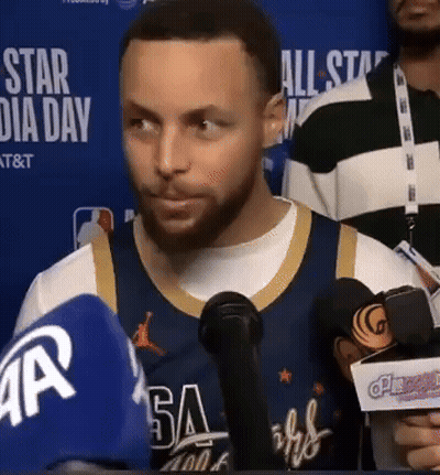 A Man Wearing A Jersey That Says Warriors Is Talking Into Microphones GIF
