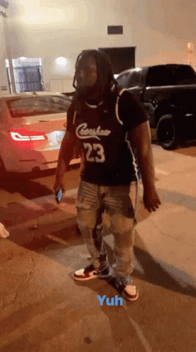 A Man Wearing A Jersey With The Number 23 On It Is Standing In A Parking Lot GIF