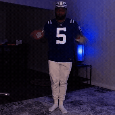 A Man Wearing A Jersey With The Number 5 On It Is Standing In A Dark Room GIF