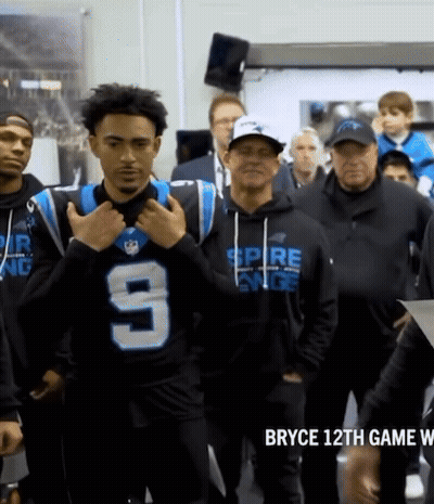 A Man Wearing A Jersey With The Number 9 On It Stands In A Crowd GIF