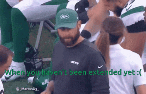 A Man Wearing A Jets Hat Talks To A Woman GIF