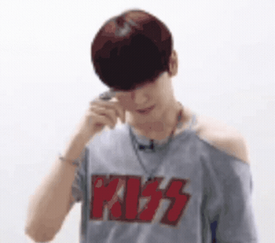 A Man Wearing A Kiss T-Shirt Is Talking On A Cell Phone . GIF