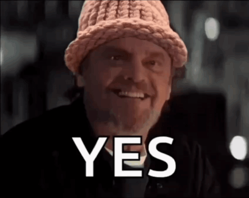 A Man Wearing A Knitted Hat Is Smiling With The Word Yes Behind Him GIF