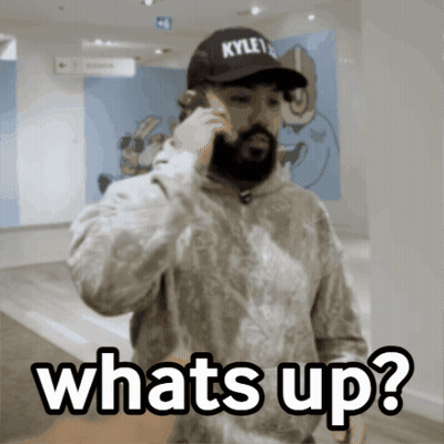 A Man Wearing A Kyle 'S Hat Is Talking On A Cell Phone And Says Whats Up GIF