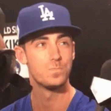 A Man Wearing A La Dodgers Hat And A Blue Shirt . GIF