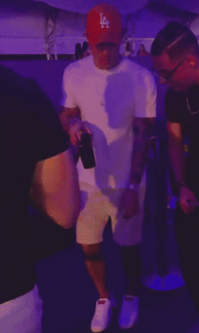 A Man Wearing A La Hat Is Dancing With Another Man GIF