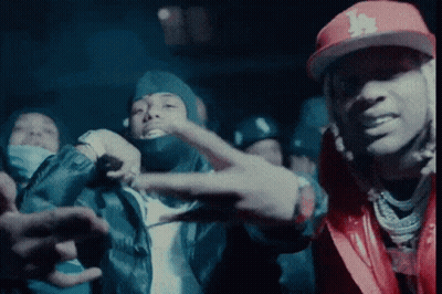 A Man Wearing A La Hat Is Giving A Peace Sign GIF