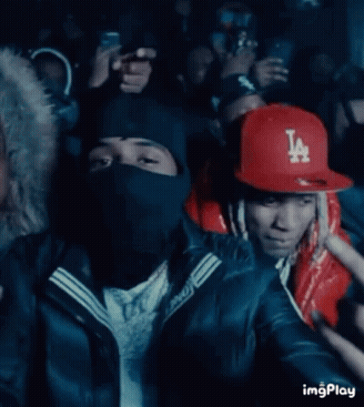A Man Wearing A La Hat Is Pointing At Something GIF