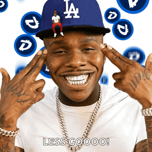 A Man Wearing A La Hat Is Smiling With His Hands On His Head GIF