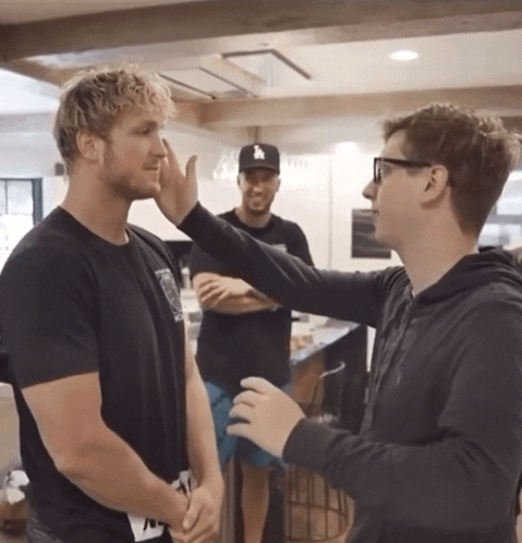 A Man Wearing A La Hat Talks To Another Man In A Kitchen GIF