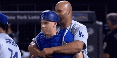A Man Wearing A La Jersey Is Hugging A Baseball Player GIF