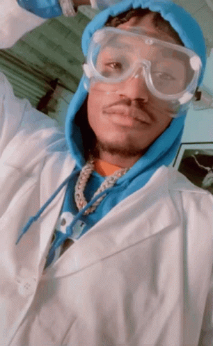 A Man Wearing A Lab Coat And Goggles Is Taking A Picture GIF