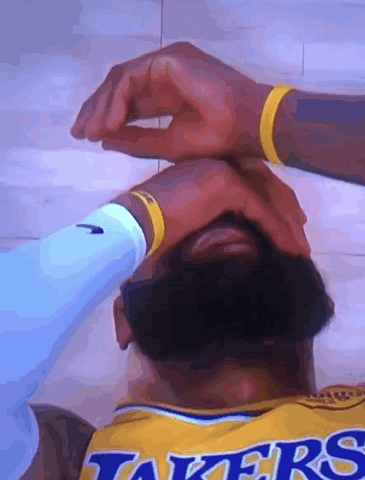 A Man Wearing A Lakers Jersey Is Laying On The Floor GIF