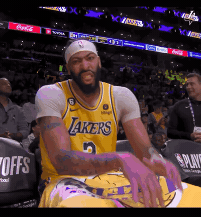 A Man Wearing A Lakers Jersey Is Sitting In The Stands GIF