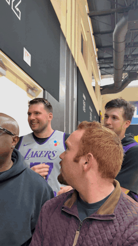 A Man Wearing A Lakers Jersey Stands In A Crowd Of People GIF